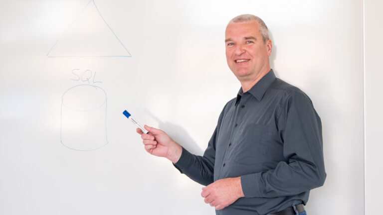OCG Mitarbeiter zeigt Traingsteilnehmern etwas auf Whiteboard